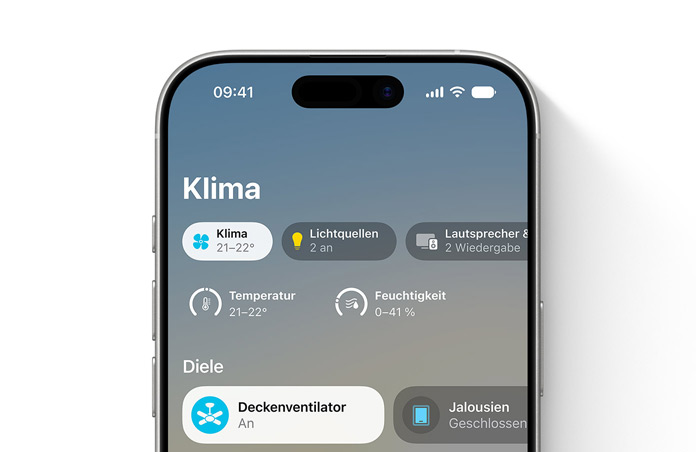 Ein iPhone Display zeigt in der Home App die Kategorie Klima, die Drehregler für Temperatur und Luftfeuchtigkeit und den Bereich Eingang mit der Steuerung für Deckenventilator und Jalousien