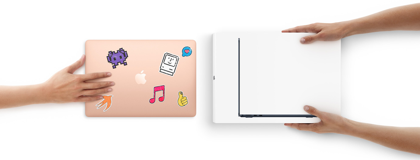 Una mano desliza un MacBook con pegatinas en la carcasa hacia dos manos que sostienen un MacBook nuevo en la caja