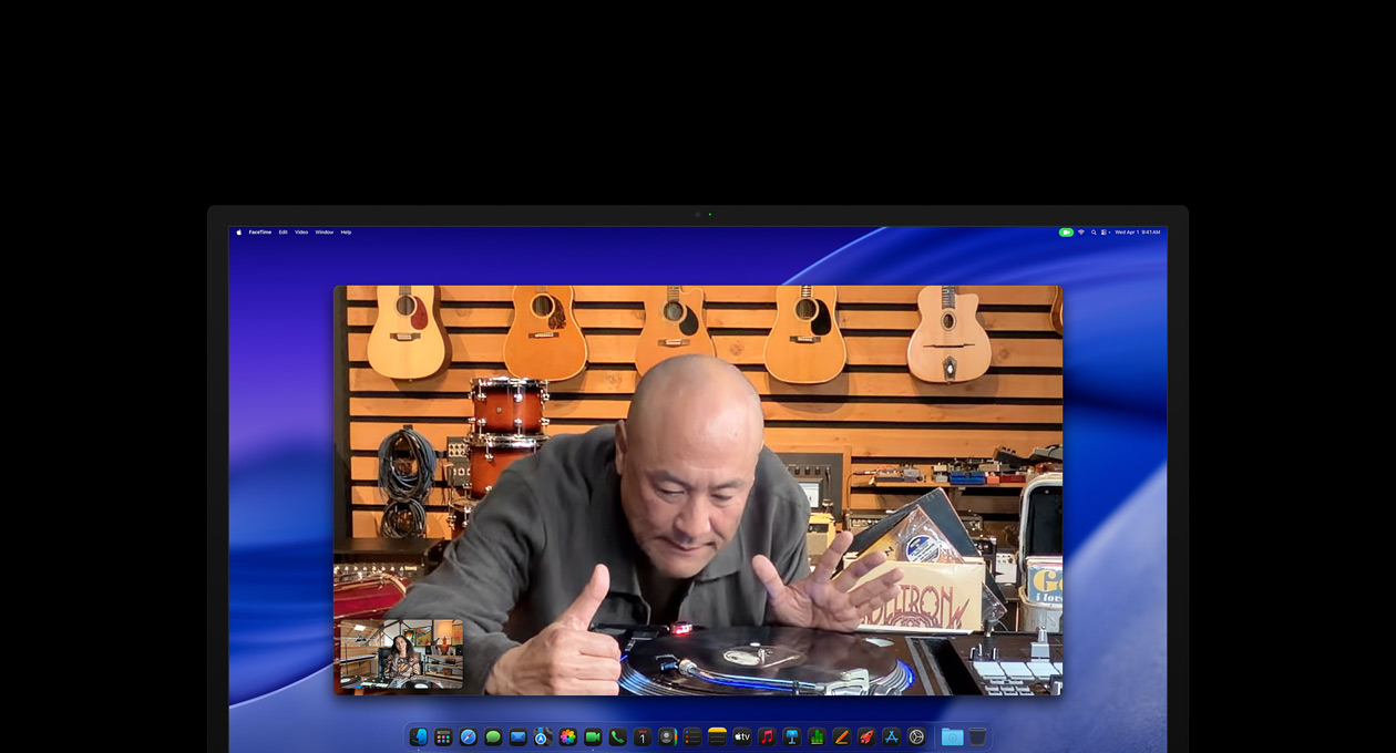 Eine Person schaut sich während eines Videoanrufs in einem Musikgeschäft einen Plattenteller genauer an und bleibt dabei dank der Center Stage Kamera in der Bildmitte