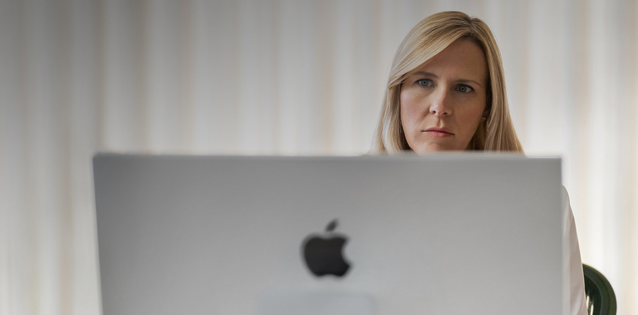 一位醫護人員從她桌後看着 iMac 熒幕。