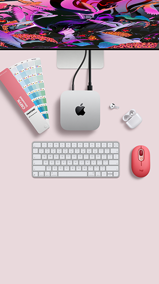 Mac mini, odozgo, srebrni aluminij, zaobljeni uglovi, sjajni crni Appleov logotip u sredini, povezan kabelom, Studio Display djelomično vidljiv odozgo, AirPod 4, otvoren, Pantone skala boja te numerička tipkovnica i miš