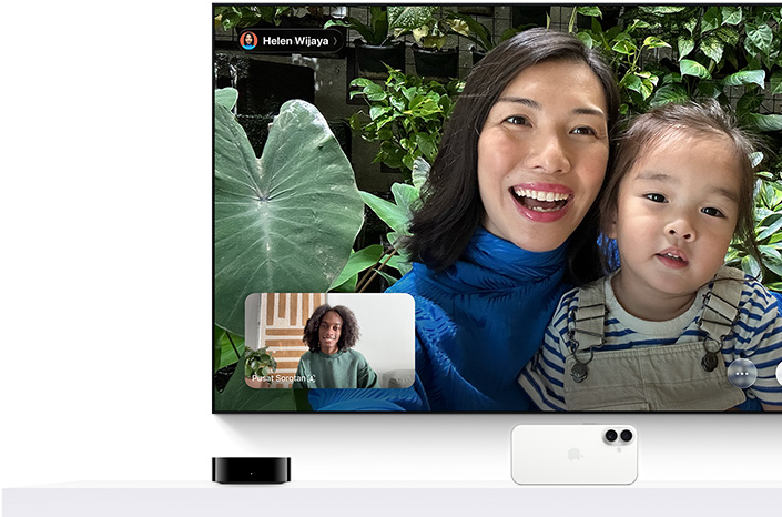 Apple TV 4K dan iPhone: Layar TV menampilkan panggilan FaceTime, seseorang memegang anak kecil, penelepon kedua dalam sisipan