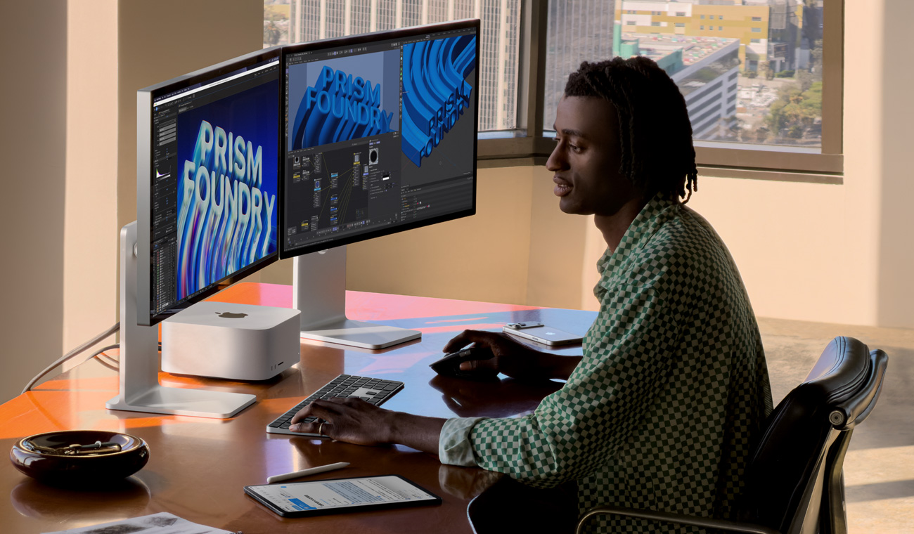 2台のStudio Displayの間にMac Studioが置かれたデスクの前に座っている人物。画面に、作業中の様々なプロジェクトのアニメーションと編集アプリが表示されている