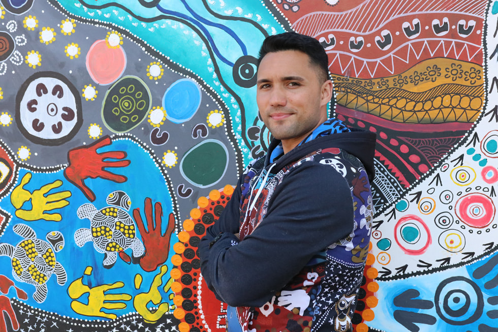 A member of ID. Know Yourself in front of a mural.