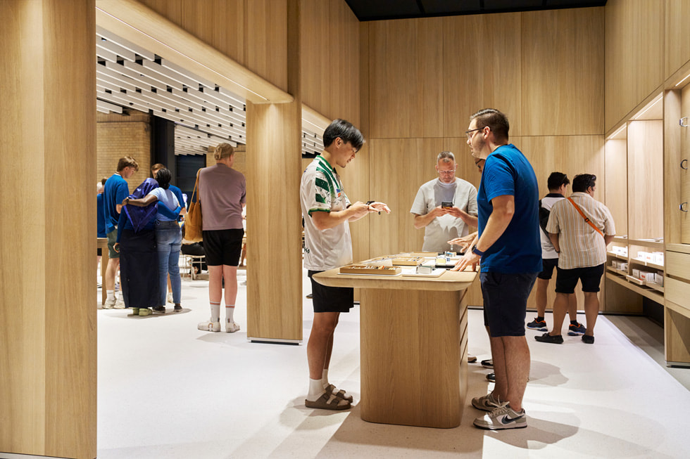 Un cliente e un dipendente al tavolo Apple Watch Studio di Apple Battersea a Londra.
