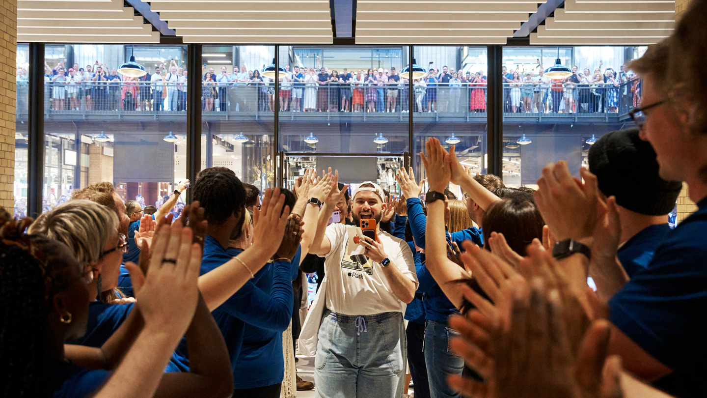 Il team che applaude ai primi visitatori di Apple Battersea. 