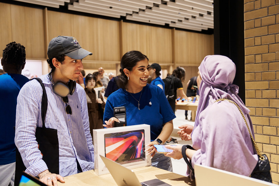 Una dipendente del team Apple che assiste una cliente con l’acquisto di un nuovo MacBook Pro.