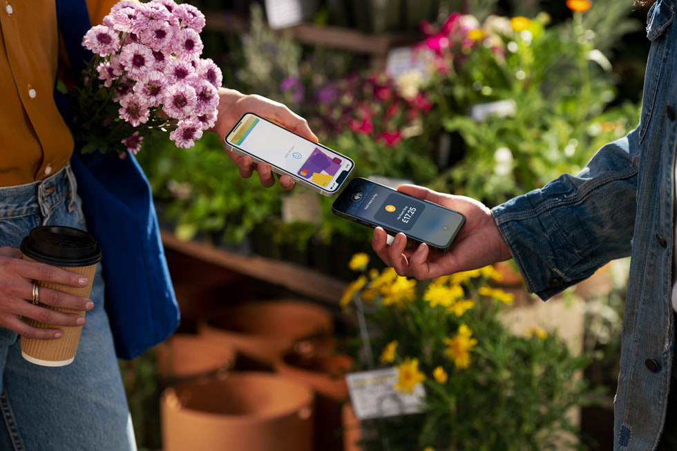 A customer holds their iPhone near a merchant’s to use Tap to Pay on iPhone.