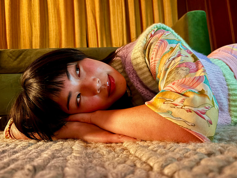 A picture taken in Night mode on iPhone 15 shows a person lying down. 
