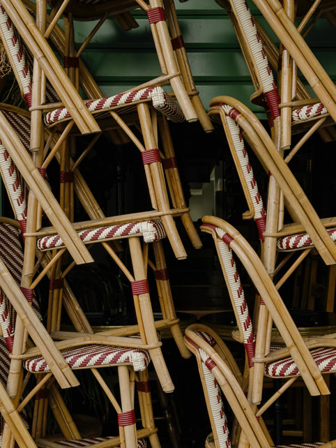 A close-up photo of bistro chairs stacked together, shot on iPhone 15 Pro Max.