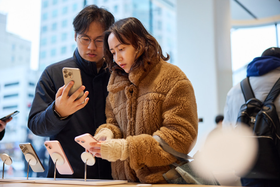 Two customers look at the iPhone 15 lineup.