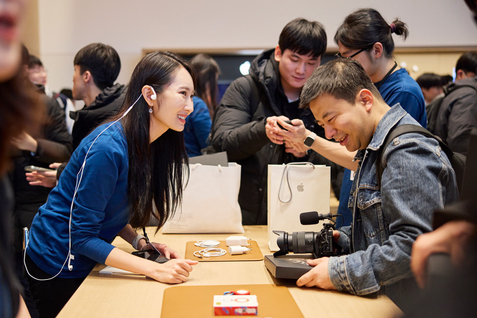 An Apple team member helps guide a customer with a purchase.