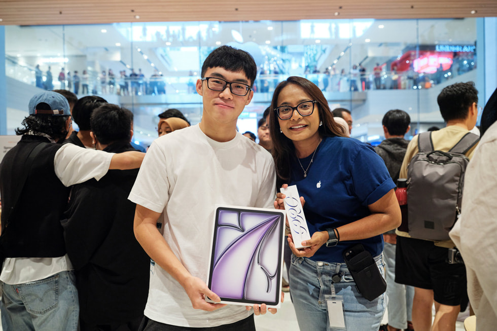 A customer with an Apple team member showing off his iPad Air and Apple Pencil Pro purchase.