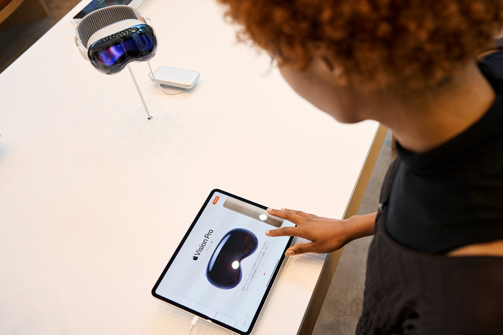 A customer scrolls through information about Apple Vision Pro on iPad.