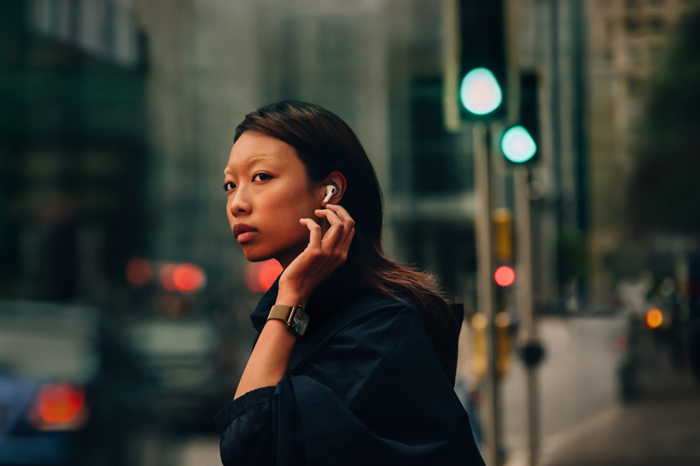 一人佩戴 AirPods 4 和 Apple Watch Series 10 ，站在街上。