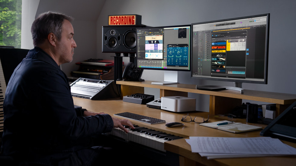 A professional working at their desk with multiple displays connected to Mac Studio.