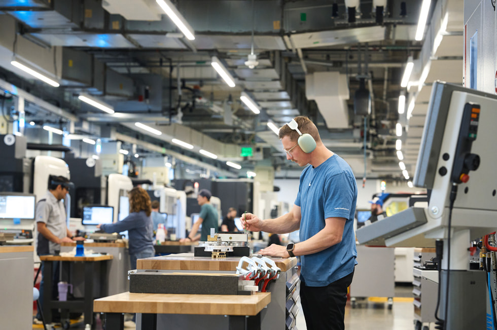 Un trabajador con audífonos examina una pieza de material en el segundo campus de Apple en Austin.