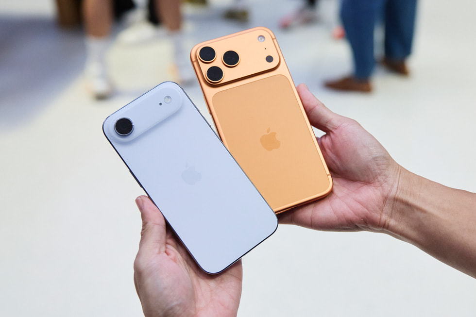 A customer compares the cloud white iPhone Air and cosmic orange iPhone 17 Pro.