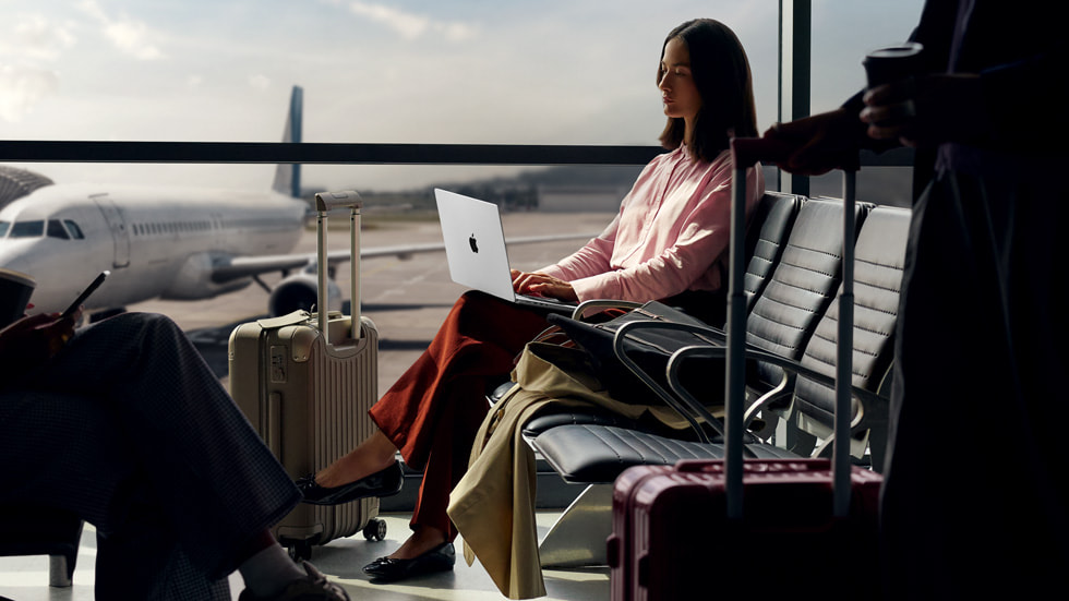 A user works on the new 14-inch MacBook Pro while waiting at an airport.