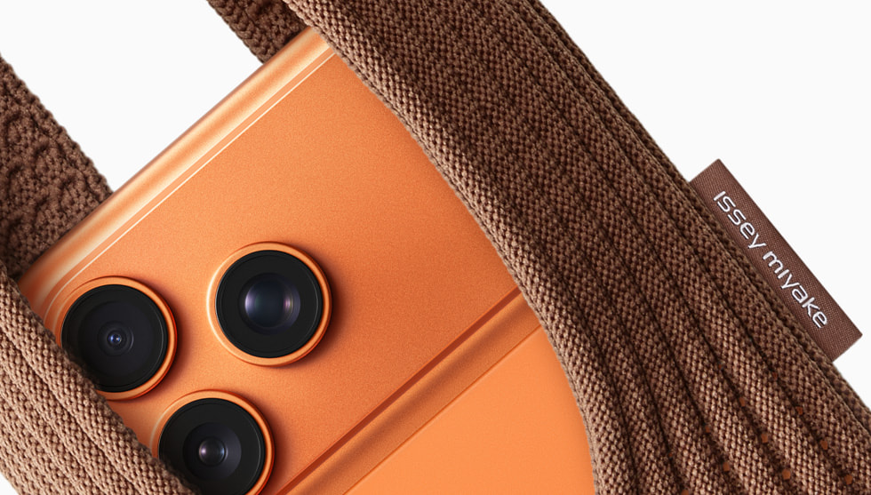 iPhone Pocket in cinnamon paired with iPhone 17 Pro in cosmic orange.