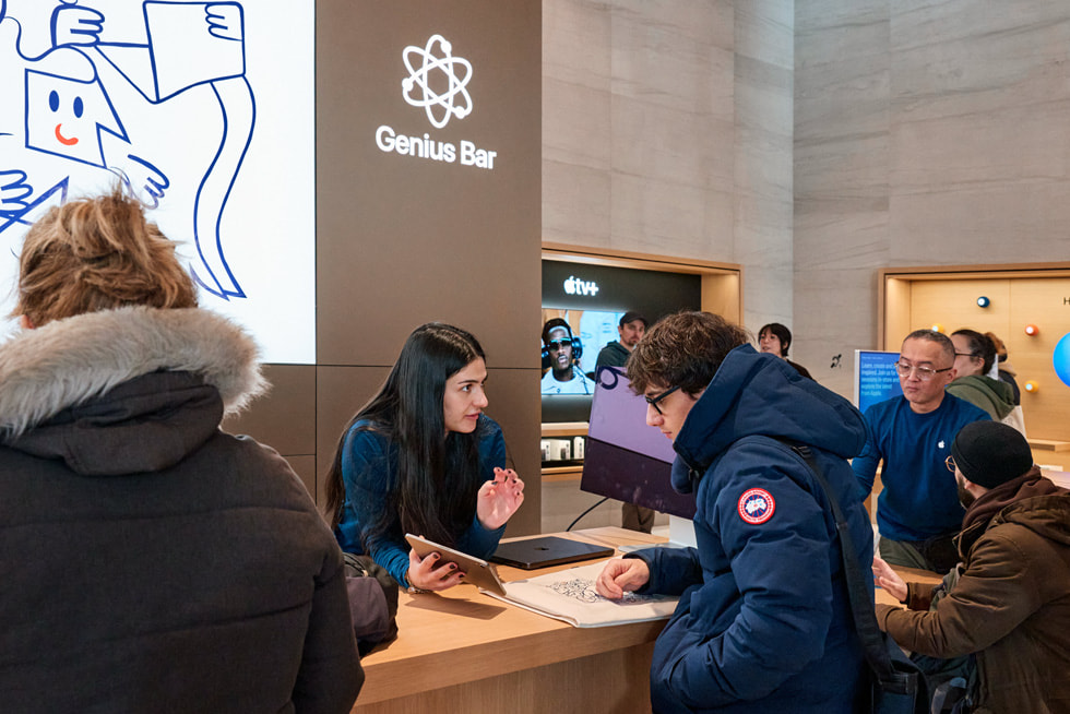 A customer chats with a Specialist at the Genius Bar inside Apple Sainte-Catherine.