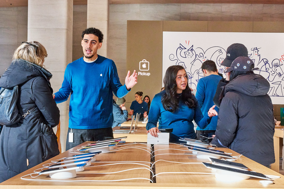 Team members and customers chat inside Apple Sainte-Catherine.