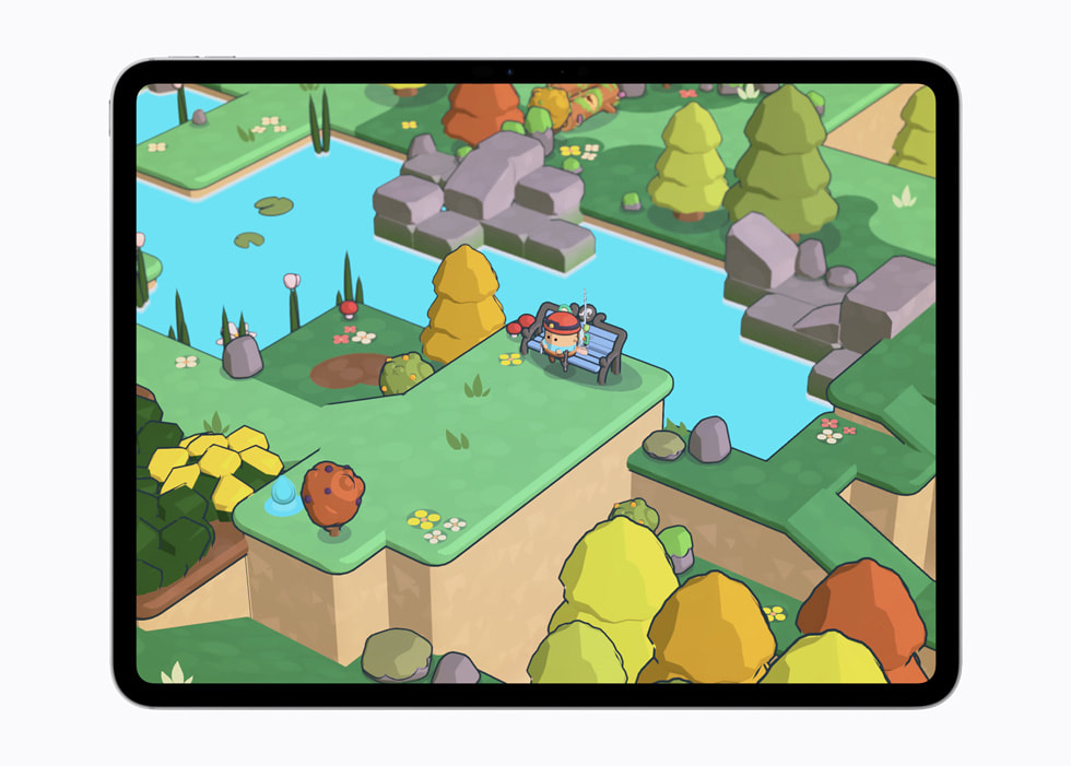 El juego Pine Hearts en un iPad Pro de 13 pulgadas muestra a un personaje en un mundo isométrico y colorido cerca de un río y algunos árboles.