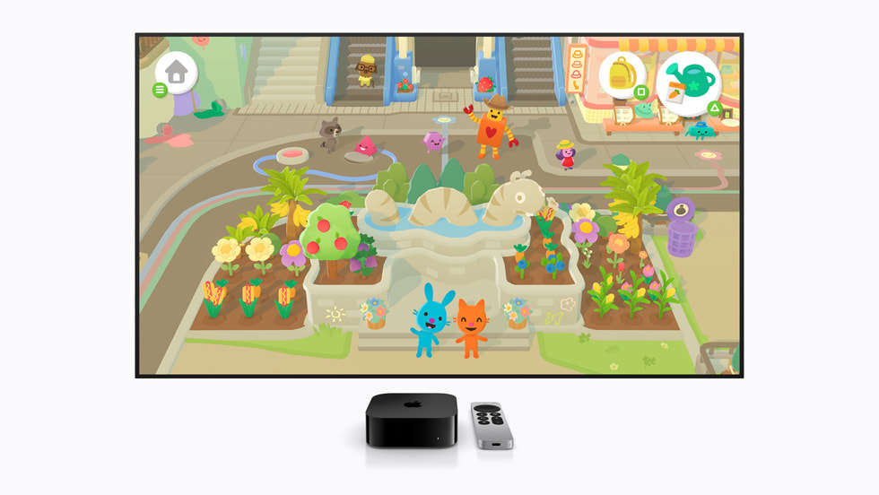 Se muestra el juego Sago Mini Jinja’s Garden en una pantalla de TV, con un Apple TV y un Siri Remote al frente, con personajes de caricatura en un jardín.