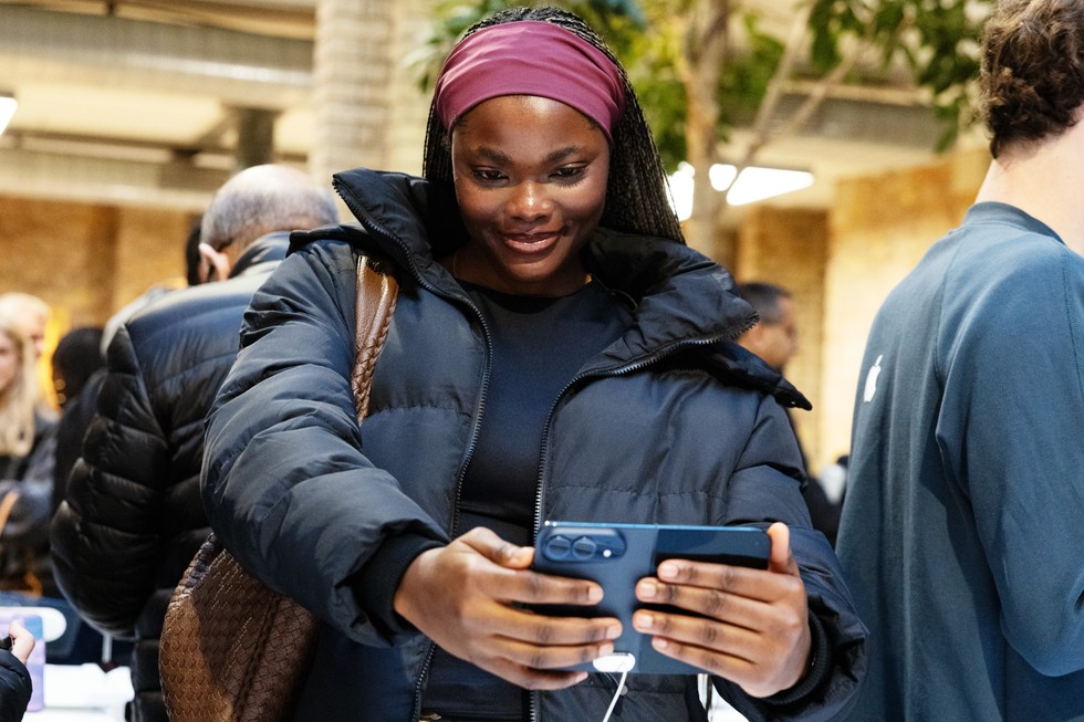 At Apple Covent Garden, a customer takes a selfie using iPhone Duo in night sky.