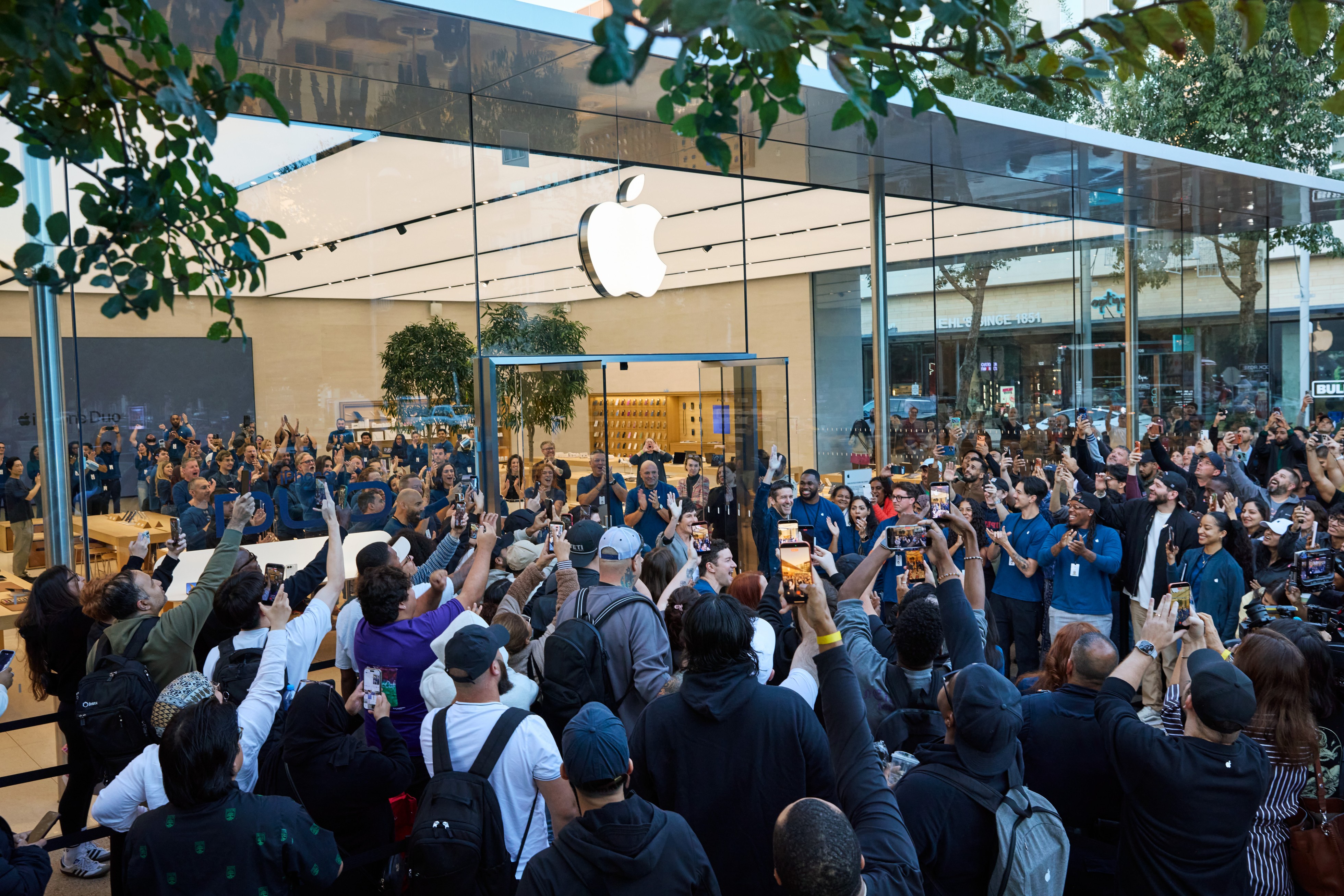 A crowd of customers in front of Apple Domain NORTHSIDE, with Deirdre O’Brien and John Ternus in the center.