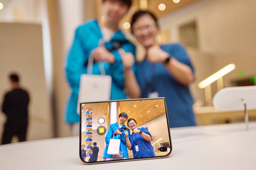 一位顧客和一位 Apple 團隊成員在 Apple 靜安使用 iPhone Duo 自拍。