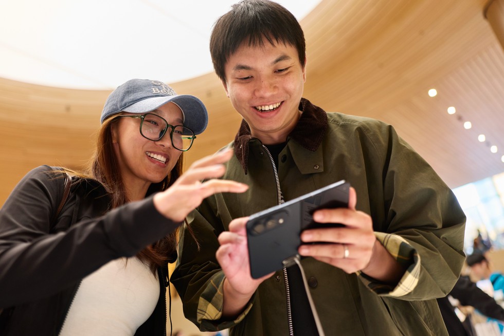 兩位顧客在 Apple 靜安試用夜空色 iPhone Duo。