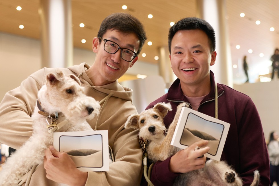 兩位顧客在 Apple 靜安拿著剛購買的 iPhone Duo，與愛犬一同入鏡。