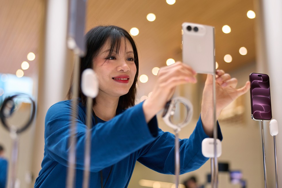一位 Apple 團隊成員在 Apple 靜安調整展示中的星光白色 iPhone Duo。