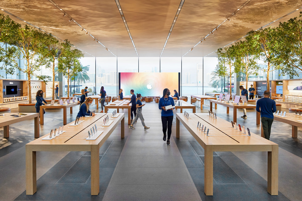 Apple Al Maryah Island team members setting up display tables inside Apple Al Maryah Island.