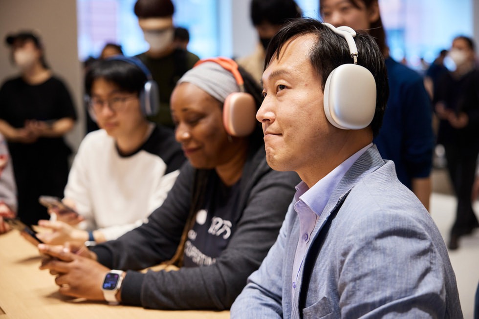 Apple 강남에서 고객이 AirPods Max를 통해 공간 음향을 경험하고 있다.