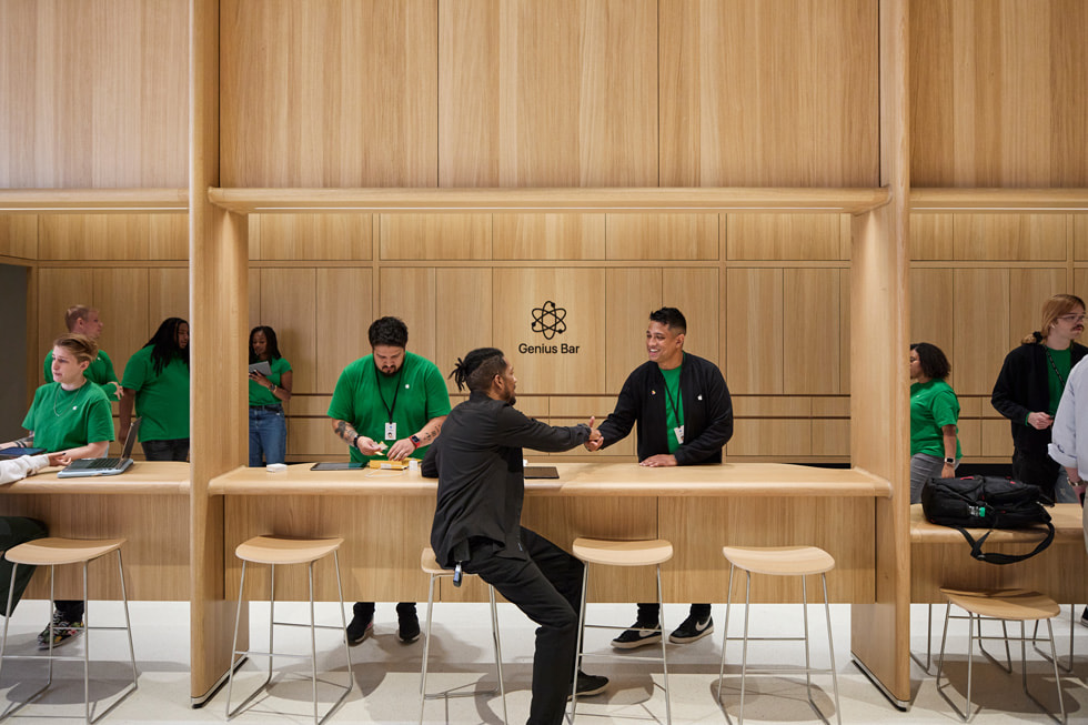 Clienti che entrano nell’Apple Tysons Corner mentre le persone del team battono le mani. 