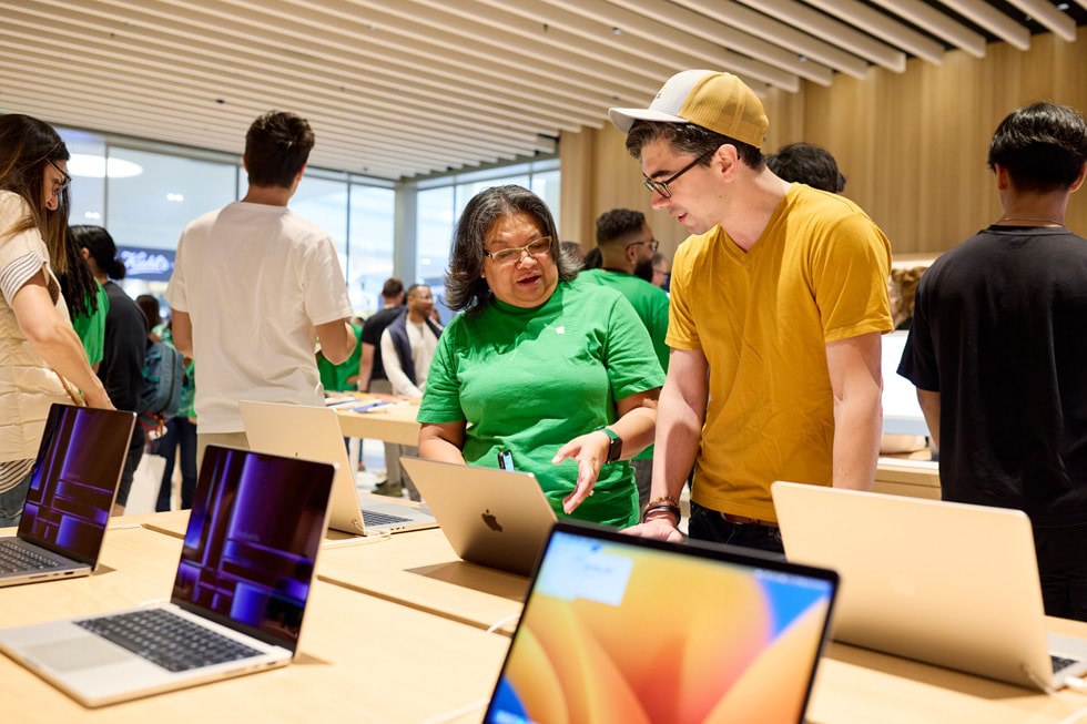 Una dipendente mostra la più recente linea Mac.