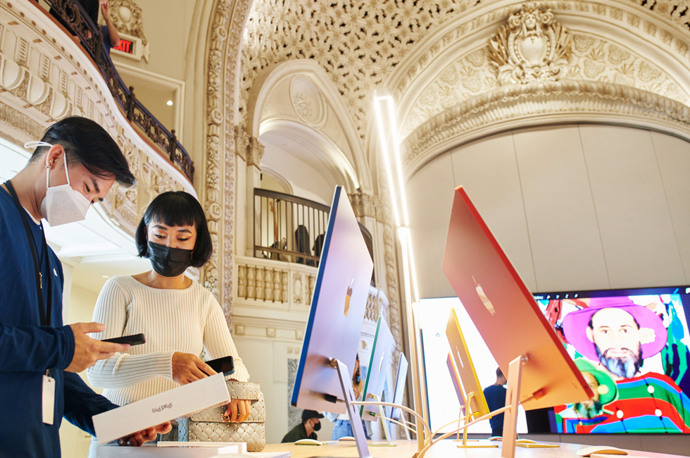 An Apple team member helps a customer purchase a new iPad Pro at Apple Tower Theatre.