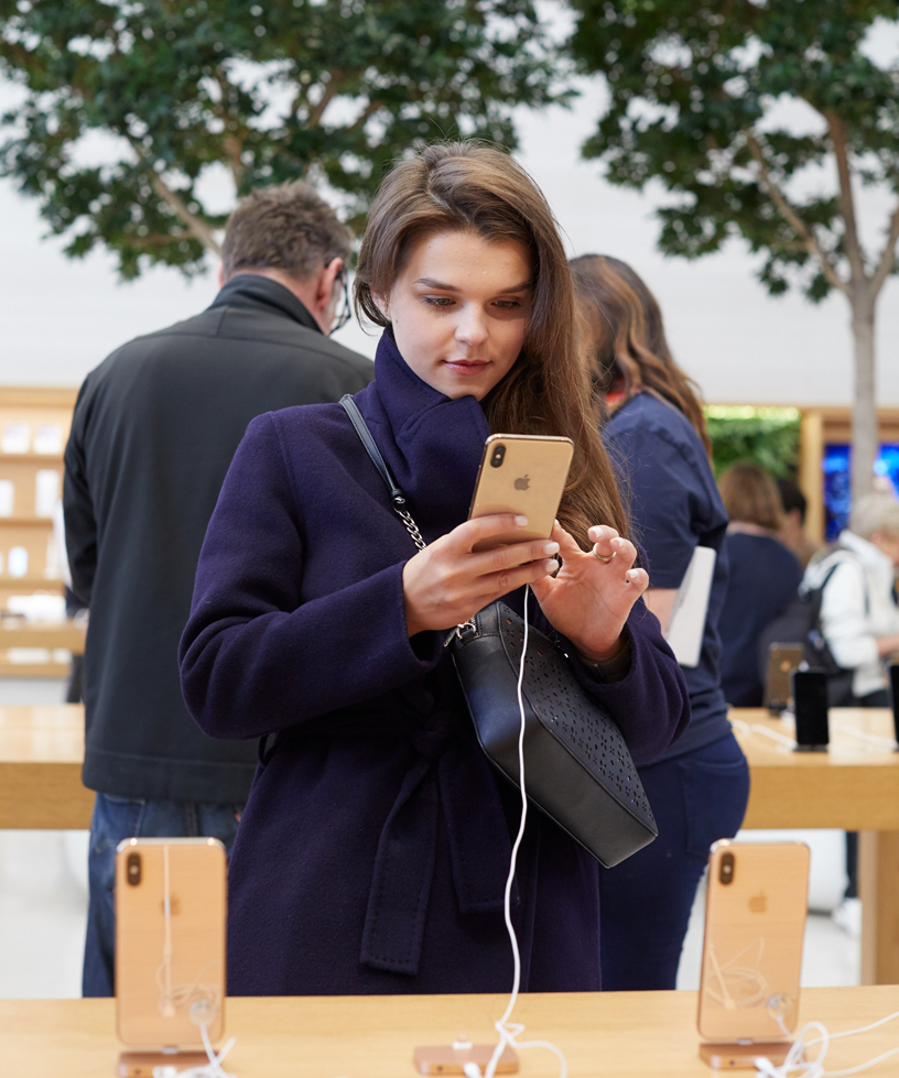 Woman holding a new gold iPhone Xs.