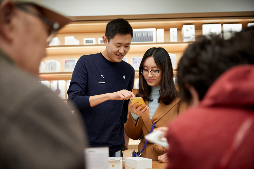 Apple team member points out iPhone XR features to a customer.