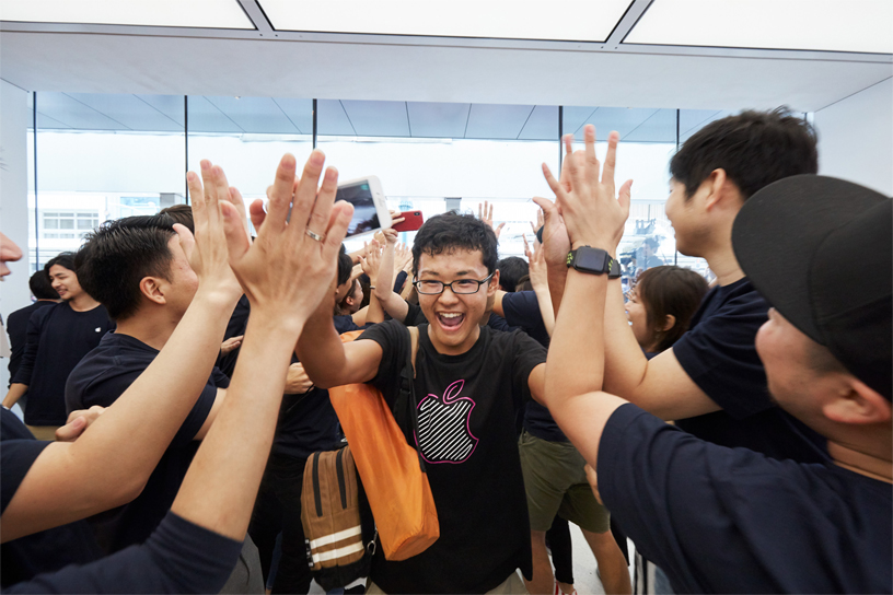 Customer getting high fives from Apple Kyoto team members.