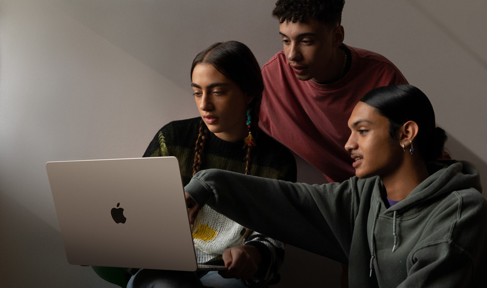 Tre personer, der kigger på 15" MacBook Air.