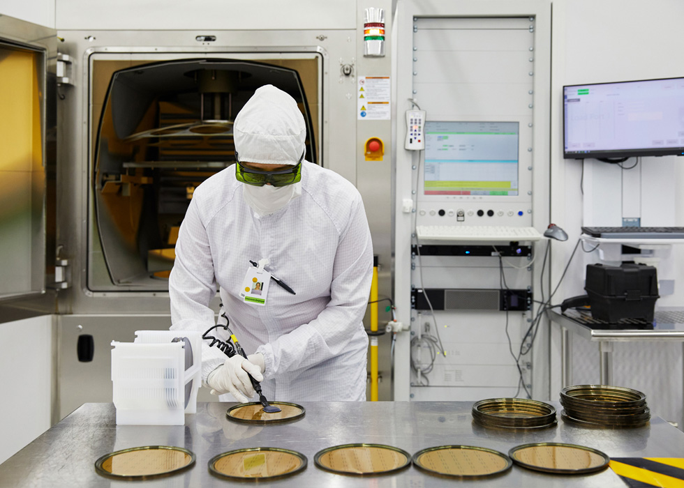 A II-VI employee inspecting components.