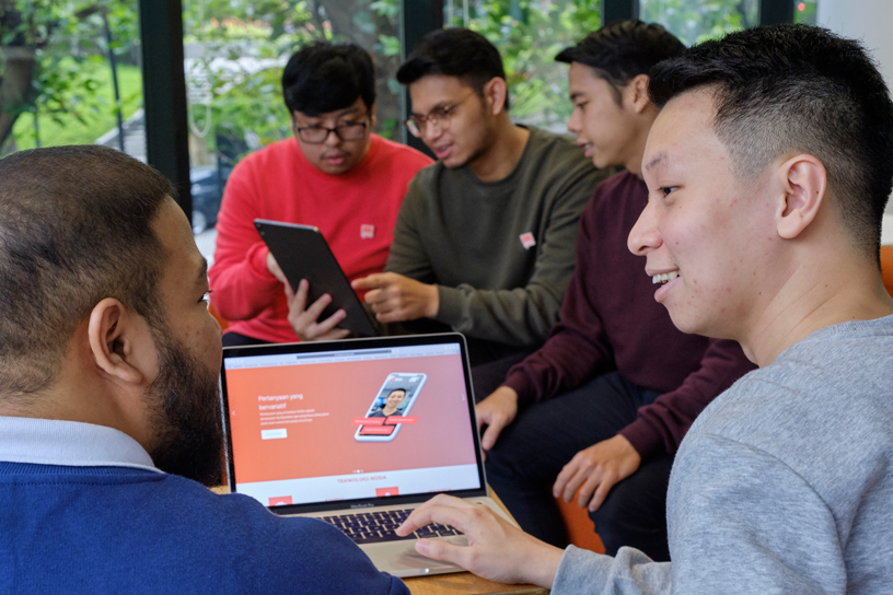 Students using a MacBook Pro and iPad.