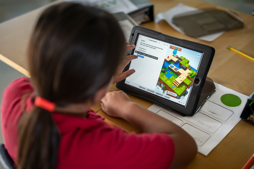 Student in classroom working on iPad.