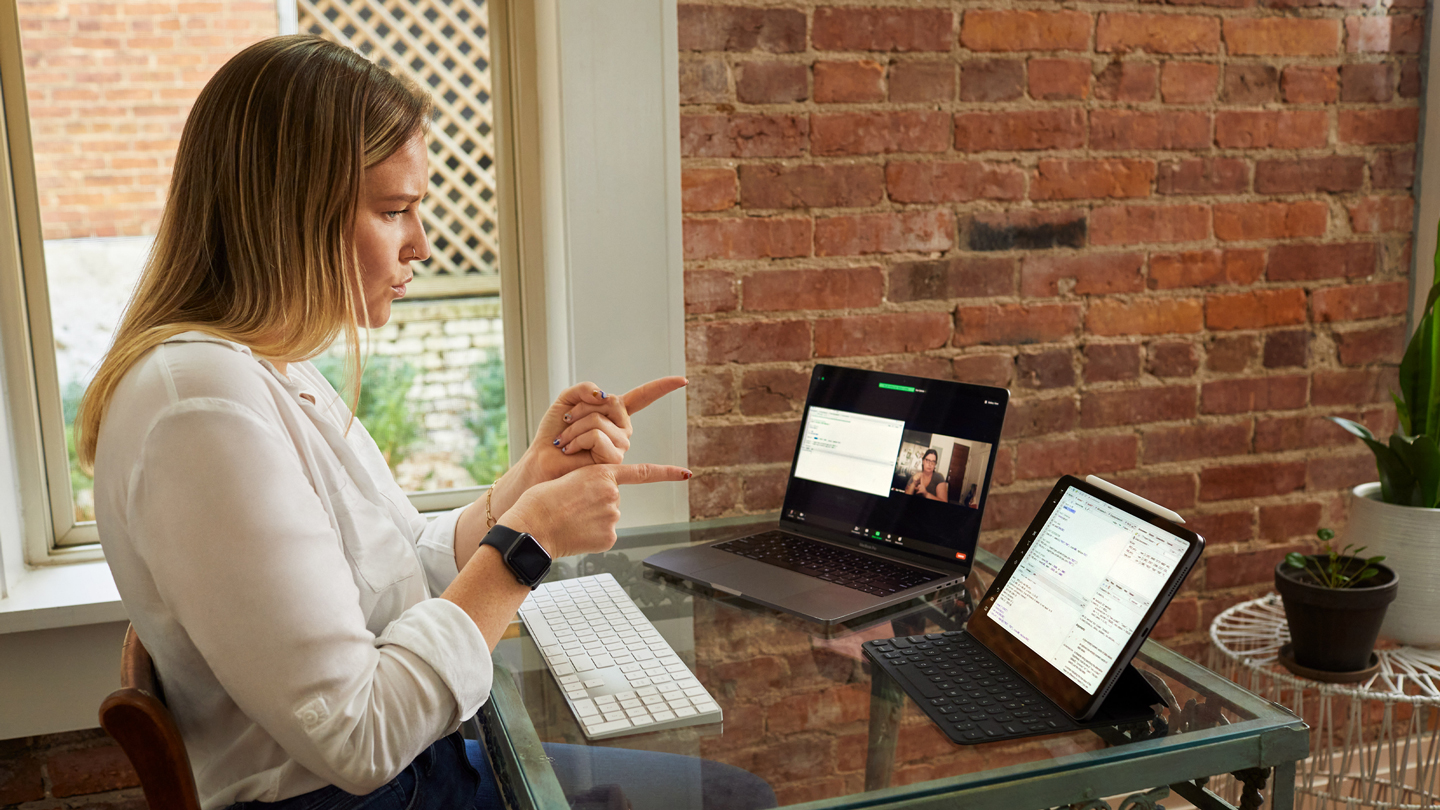 SaraBeth Sullivan using American Sign Language with her iPad Pro and MacBook Pro.