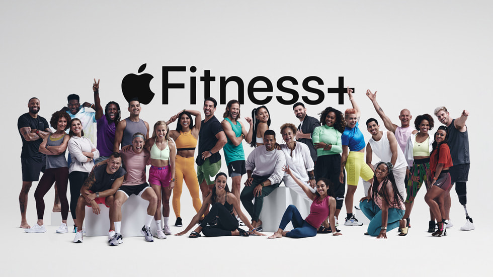 Gruppenfoto vieler Fitness+ Trainer:innen vor einem Apple Fitness+ Logo.