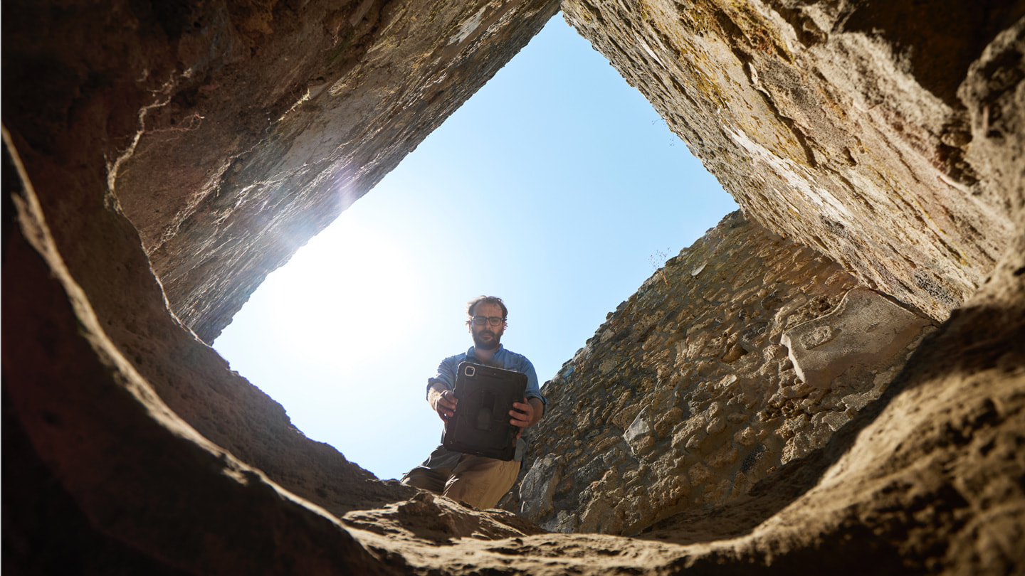 Shot from within an excavation pit looking up, Dr. Rogers is seen holding iPad Pro over the pit’s opening.