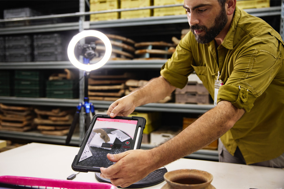 Dr. Badillo angles iPad Pro over a mask in an office.